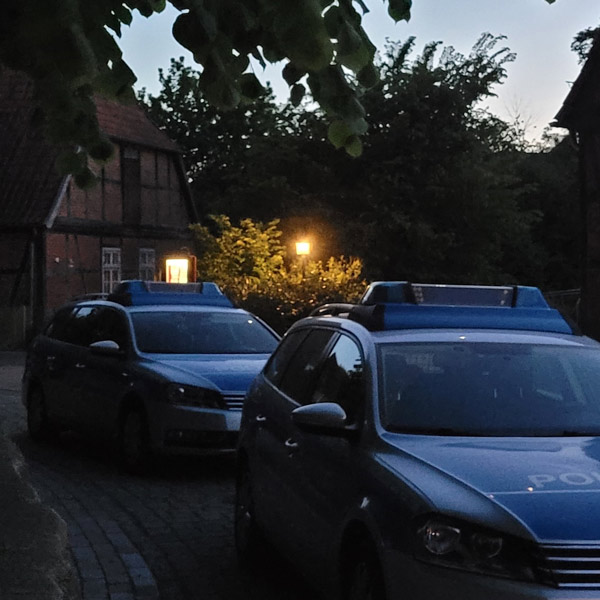 Polizeiautos vor Haus in der Dämmerung